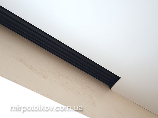 чорний карниз інтегрований в натяжну стелю впритул до стіни
